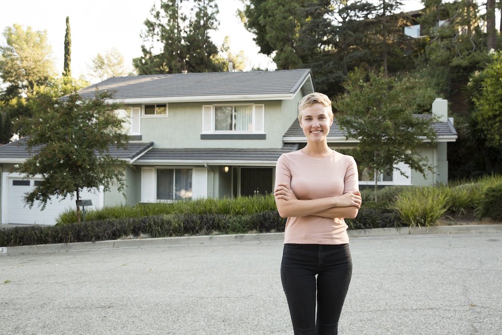 Portrait of smiling woman in front of her home